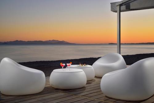 福洛尼卡The Sense Experience Resort的海滩上一组白色的桌椅