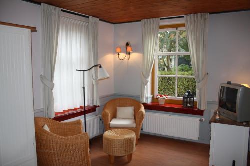 布尔坦赫城布尔坦赫弗斯丁酒店的客厅配有电视、椅子和窗户