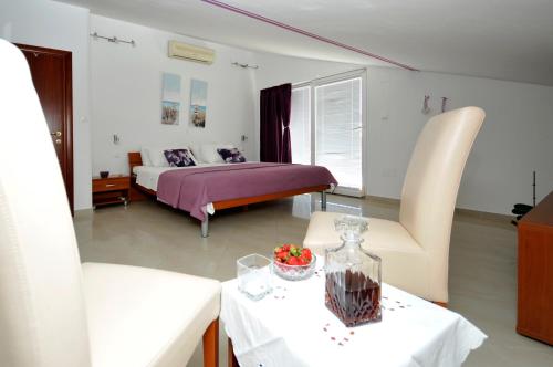 特罗吉尔Apartments Roza的卧室配有一张床和一张桌子及椅子