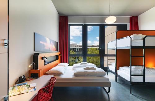 日内瓦MEININGER Hotel Genève Centre Charmilles的一间卧室配有两张双层床和一张书桌