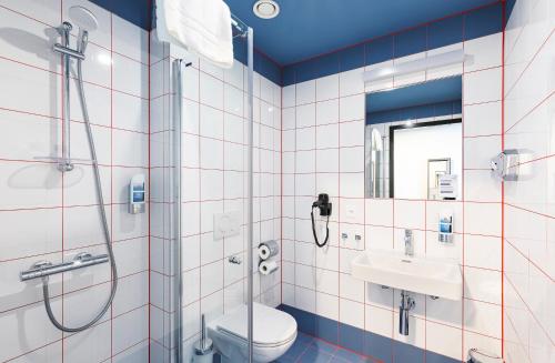 日内瓦MEININGER Hotel Genève Centre Charmilles的带淋浴、卫生间和盥洗盆的浴室