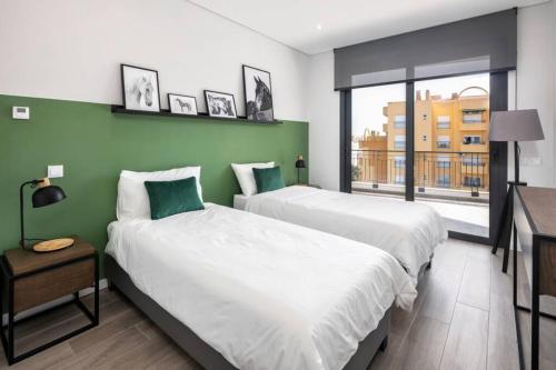 波尔蒂芒Apartment Confort 404的绿墙客房的两张床