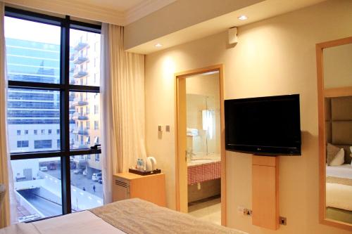 迪拜The Leela Hotel的酒店客房设有电视和大窗户。