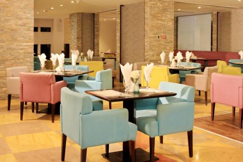 迪拜The Leela Hotel的一间在房间内配有桌椅的餐厅