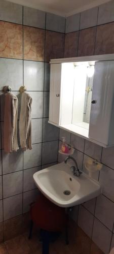 瓦西利卡koula's apartments的浴室配有盥洗盆、橱柜和毛巾。