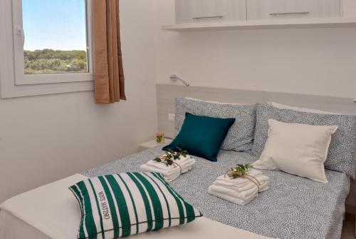 奥特朗托Tenuta l'Alba di Monte Matino - Mobil Home的一间卧室配有带两个枕头的床和窗户