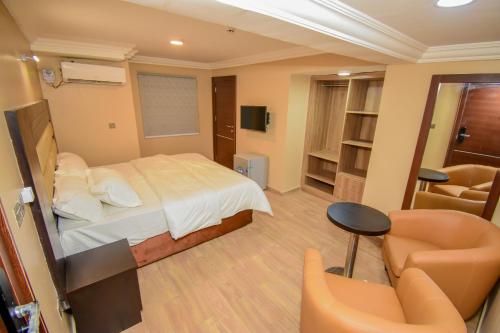 SagisaFadar's Place Hotel的一间卧室配有一张床、一张沙发和一把椅子