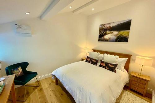科姆堡Paddock View, Castle Combe的卧室配有白色的床和椅子