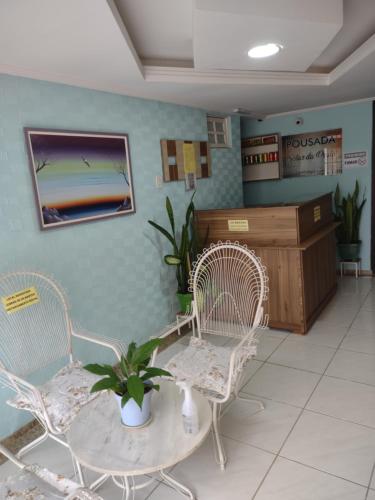 瓜拉派瑞Pousada Solar da Praia的一间设有两把椅子和一张桌子的等候室