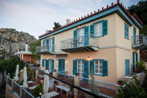 纳夫普利翁阿克罗纳福利亚A旅馆的蓝色百叶窗和阳台的房子