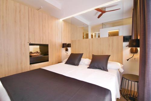 塔拉戈纳ESTUDIO PORT EXPERIENCE的一间卧室设有一张大床和一个壁炉