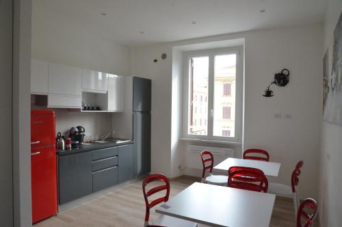 罗马SunnyCornerinRHome的厨房配有红色冰箱、桌子和椅子