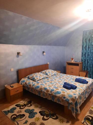 波洛夫拉吉Pensiunea Ana-Maria的一间卧室配有一张蓝色墙壁和蓝色窗帘的床