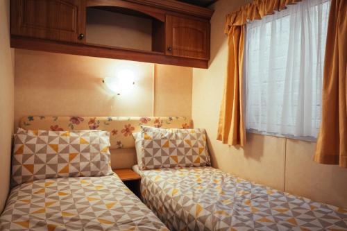 波特拉什Aaranmore Mobile Home的小房间设有两张床和窗户