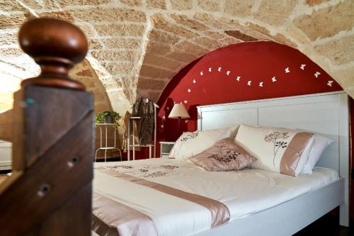 莱切伊索拉德罗斯坦帕托尔住宿加早餐旅馆的卧室配有白色的床铺和红色的墙壁