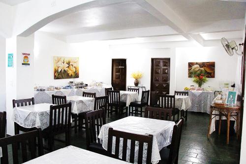 卡纳内亚Pousada Berro D'Água的用餐室配有桌椅和白色桌布