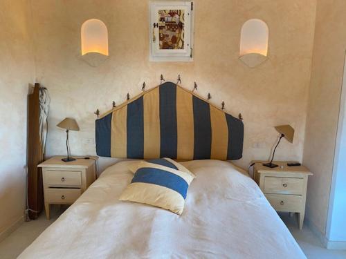 切尔沃港Villa Quiete a Porto Cervo的一间卧室配有一张带条纹床头板的大床