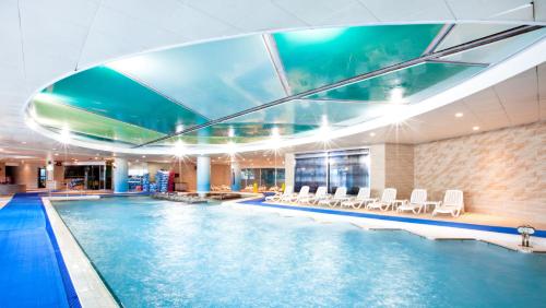 束草市Delpino的游泳池,酒店内设有椅子和游泳池