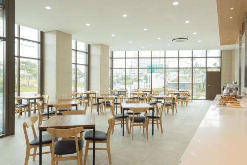 襄阳郡CENTUMMARK Hotel YangYang的用餐室设有桌椅和窗户。