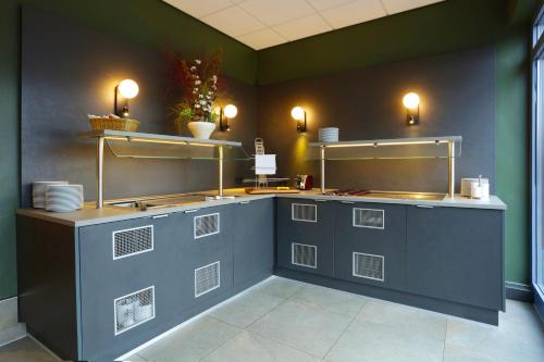 阿希姆格里斯切酒店的厨房配有带板子和灯的柜台