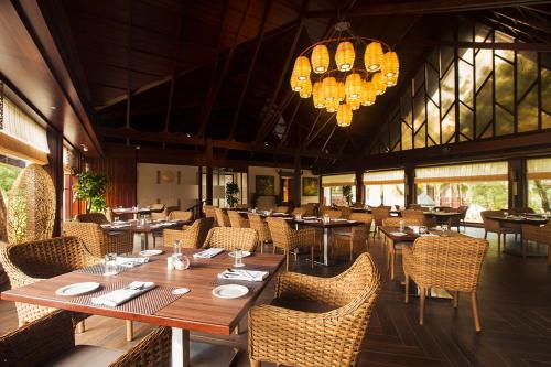 尼尔岛Sea Shell Samssara的餐厅设有木桌、椅子和吊灯。