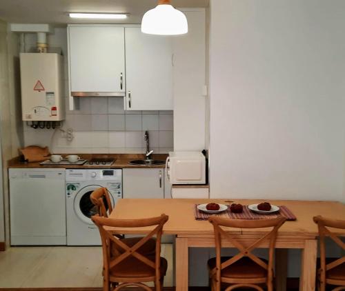 桑坦德Apartamento en Reina Victoria的厨房配有木桌、椅子和炉灶