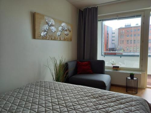 于韦斯屈莱Lutakko Apartment 2 with free car parking的卧室配有床、椅子和窗户。