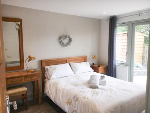 波特马多克Abergafren Lodge的一间卧室配有一张床、一张书桌和一面镜子