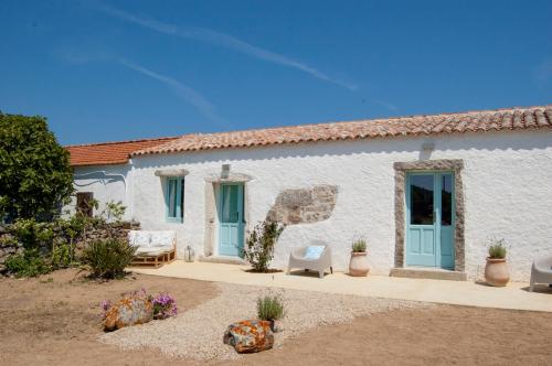 圣特雷莎加卢拉Massidda Country Retreat的白色的房子,有蓝色的门和院子