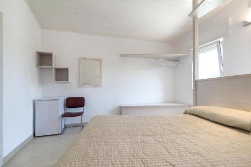 卡萨拉诺Tenuta Andromeda的一间卧室配有一张床和一把椅子