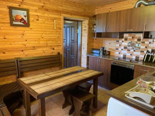 SzackГостинний дім的小屋内的厨房配有木桌