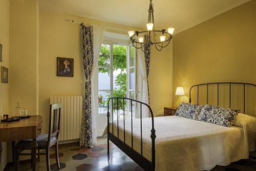 法杰托拉廖B&B Villa le Ortensie的一间卧室配有一张床、一张书桌和一个窗户。
