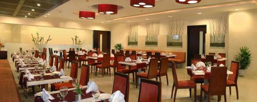 维沙卡帕特南Fortune Inn Sree Kanya, Visakhapatnam - Member ITC's Hotel Group的餐厅内带桌椅的用餐室