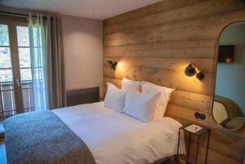 拉克吕萨农场酒店的卧室配有白色的床和木墙