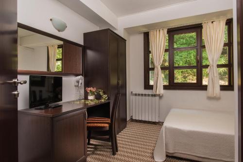 贝里奥苏姆碧蕾家庭旅馆的一间卧室配有书桌、床和窗户。