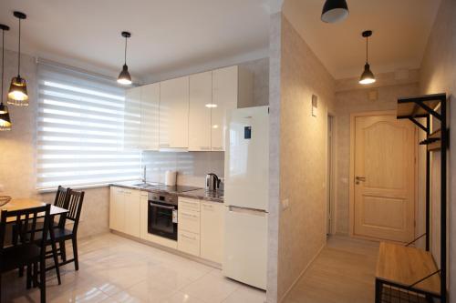 林巴日Centra apartamenti Elīza的一间厨房,配有白色家电和桌椅