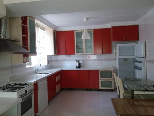 Macka卡姆利克公寓的一间厨房,里面装有红色橱柜和一张桌子