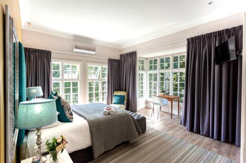 彼得马里茨堡Taunton Manor的一间卧室设有一张床和一些窗户。