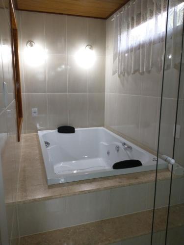 维奥康德马奥Chalés do Pardal的浴室设有白色浴缸,配有两盏灯