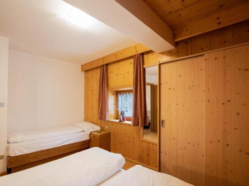 博萨迪法萨Ciasa Lino Aloch的一间卧室设有两张床和窗户。