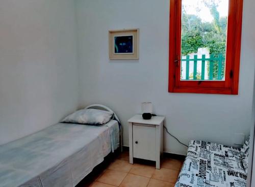 托里德欧索Casa con giardino sulla Poesia的一间卧室配有一张床和一张桌子及窗户