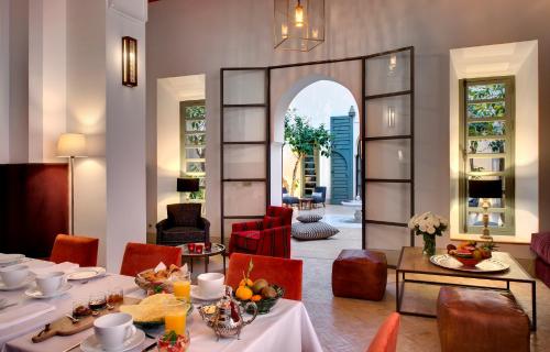 马拉喀什里亚德安塔拉旅馆的一间带桌椅和镜子的用餐室