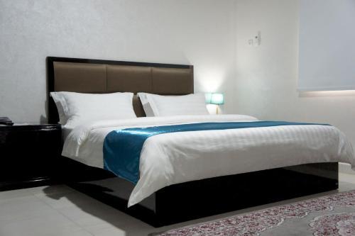 努瓦迪布Valencia Hôtel & Appartements的一间卧室配有一张带蓝色毯子的大床