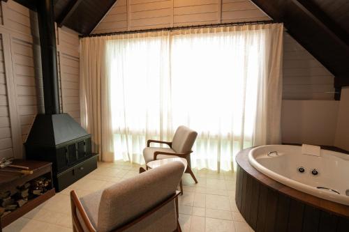 加斯帕Resort Ecoar的带浴缸、椅子和窗户的浴室
