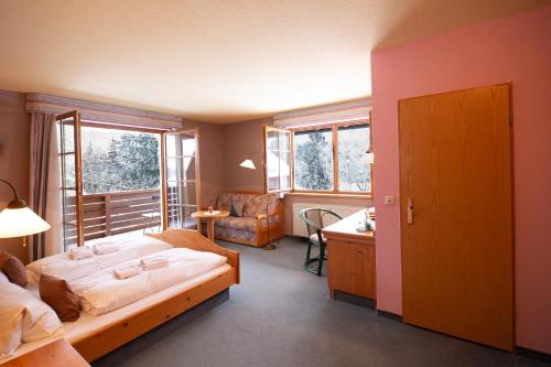 GrünbachFlößerstube的一间卧室配有一张床、一张书桌和窗户。