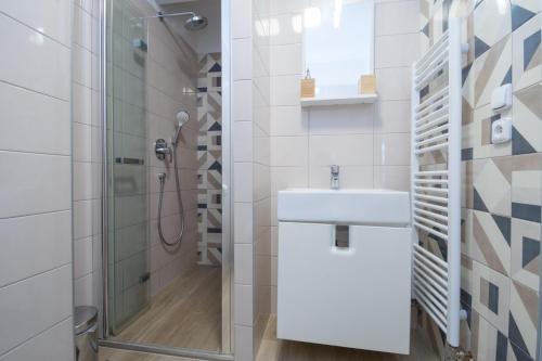 奥洛穆茨Sunny apartment的白色的浴室设有水槽和淋浴。