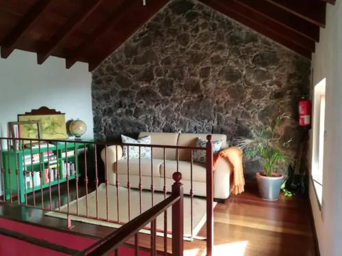 GuarazocaCasa Rural Los Mozos的带沙发和石墙的客厅
