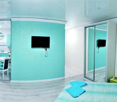 第聂伯罗Tiffany apartment in the center的蓝色的房间,设有床铺和墙上的电视
