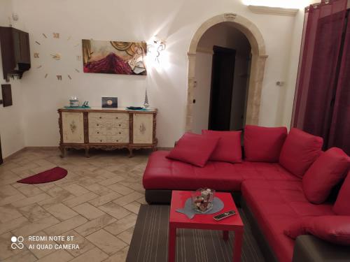阿卡亚La casa nel borgo的客厅配有红色的沙发和桌子