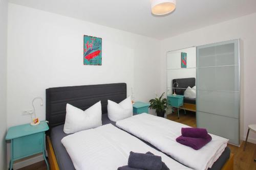 奥斯特巴德·哥伦F-1093 Villa Elise Ferienwohnung Nr 01的一间卧室配有两张带白色和紫色枕头的床